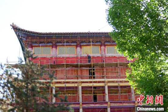 圖為5月上旬，甘肅山丹縣大佛寺內(nèi)，工作人員對(duì)古建筑大雄寶殿進(jìn)行修繕。 中新社記者 高展 攝