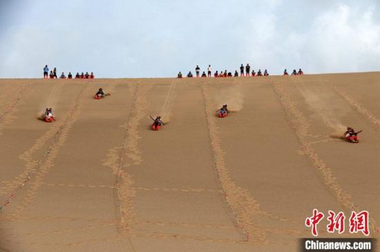 6月13日，敦煌鳴沙山月牙泉景區(qū)舉辦滑沙比賽。　張曉亮 攝