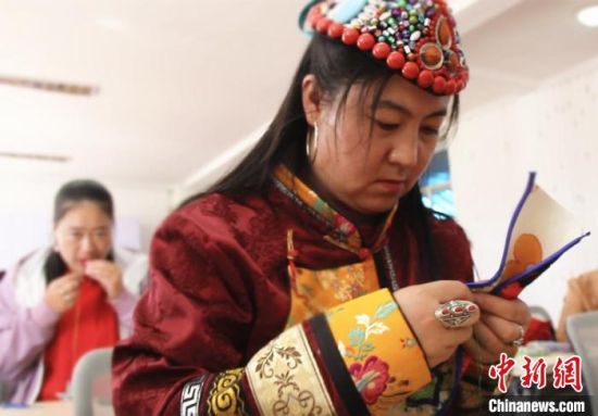 圖為裕固族婦女學(xué)習(xí)刺繡?！∈缝o靜 攝