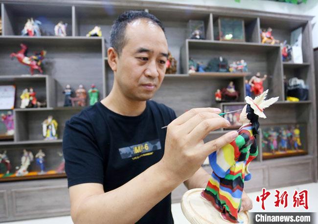 圖為安秋平正在創(chuàng)作代表隴南文縣民俗的《白馬人》作品?！「哒?攝