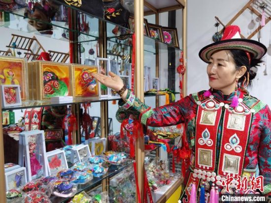 圖為身著民族服飾的隴原巧手展示手工藝品。(資料圖) 徐雪 攝