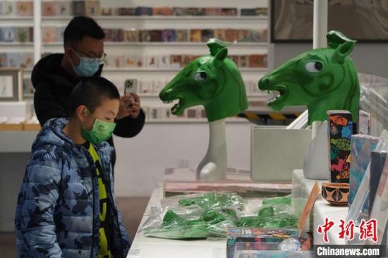 圖為“神馬來(lái)了”銅奔馬頭套吸引參觀者駐足?！【琶赖┰?攝