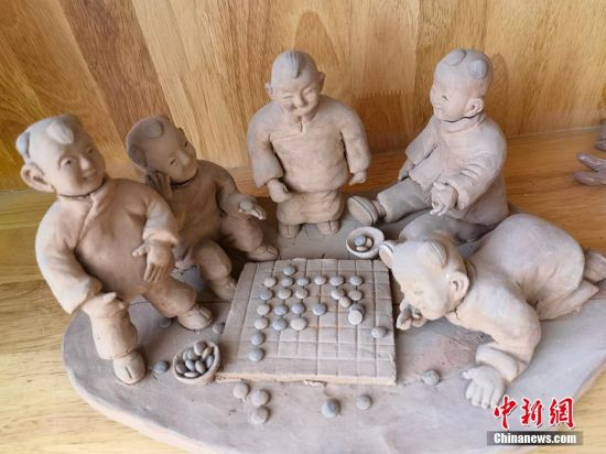 圖為泥塑作品展現(xiàn)下棋場景。 劉玉桃 攝