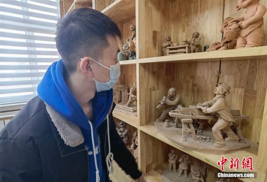 圖為學(xué)生欣賞泥塑作品。 劉玉桃 攝