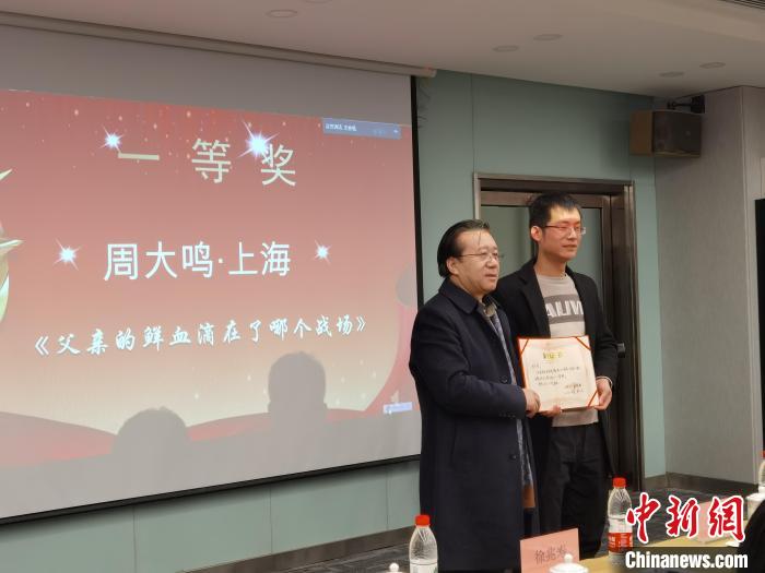 圖為作家、西北師范大學新聞與傳媒學院院長徐兆壽頒發(fā)一等獎證書，代領獎者上臺領獎?！钅?攝