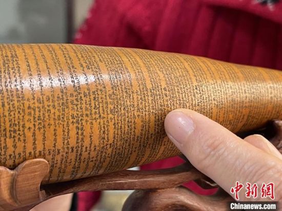 圖為長約二十公分的長條葫蘆雕刻佛教經(jīng)文作品?！堟?攝