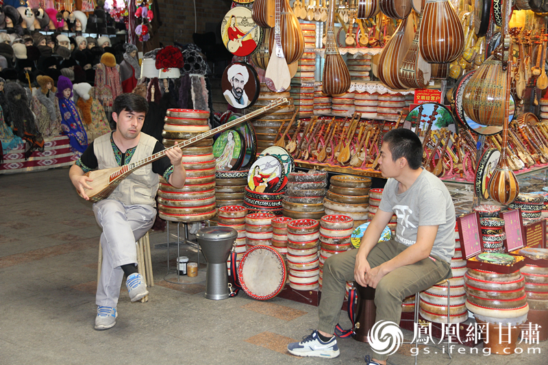 烏魯木齊二道橋巴扎內(nèi)，店主正在向客人展示樂器。楊文遠 攝