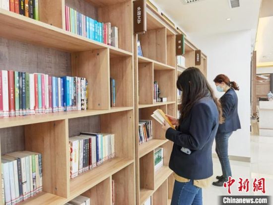 圖為在甘肅公航旅建設(shè)集團有限公司的職工書屋，職工挑選書籍?！⌒煅?攝