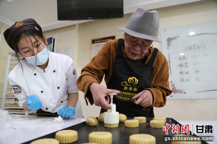 當(dāng)日，受邀參加活動的臺胞臺屬代表、兩岸婚姻及子女、在甘臺商代表等歡聚一堂。圖為77歲的在甘臺胞潘天鑒制作月餅。九美旦增 攝