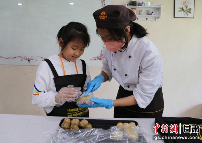 圖為在甘臺胞小朋友在工作人員指導(dǎo)下制作月餅。九美旦增 攝