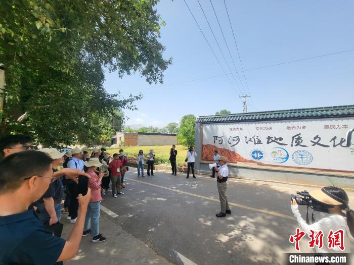 圖為中國地質(zhì)大學(xué)(北京)教授張緒教介紹村落情況。　胡友軍 攝