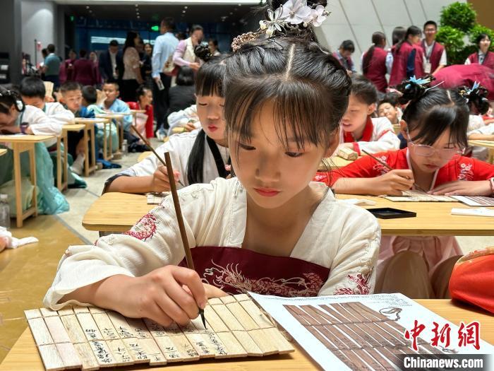 圖為小朋友在甘肅簡牘博物館練習(xí)書法?！≈行律缬浾?戴文昌 攝