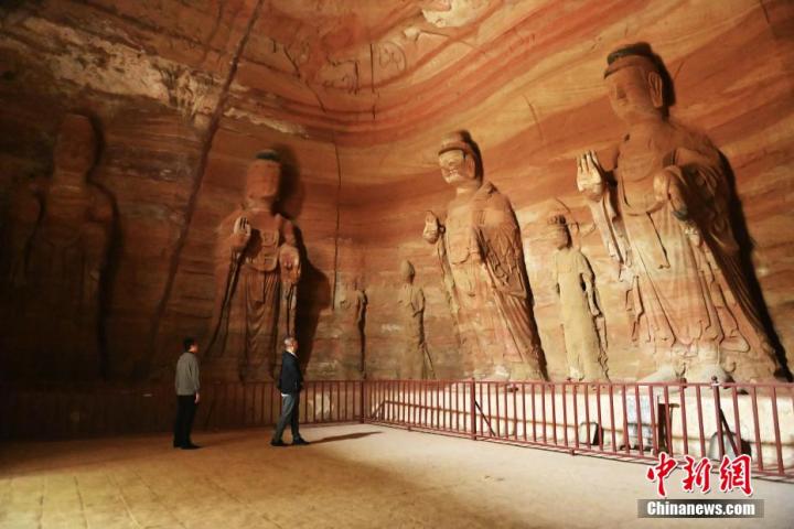 7月15日，游人參觀甘肅省平?jīng)鍪袥艽h百里石窟長廊中的南石窟寺1號窟。百里石窟長廊位于涇川縣境內(nèi)，由512個石窟、5眼窟中石井組成，現(xiàn)存王母宮石窟、鳳凰山石窟、南石窟寺、丈八寺石窟、羅漢洞石窟、太山寺石窟等規(guī)模較大的石窟群，還有數(shù)量眾多的小石窟群。南石窟寺開鑿于北魏永平三年，其中1號窟屬于大型七佛窟，七佛高達6米。中新社記者 李亞龍 攝